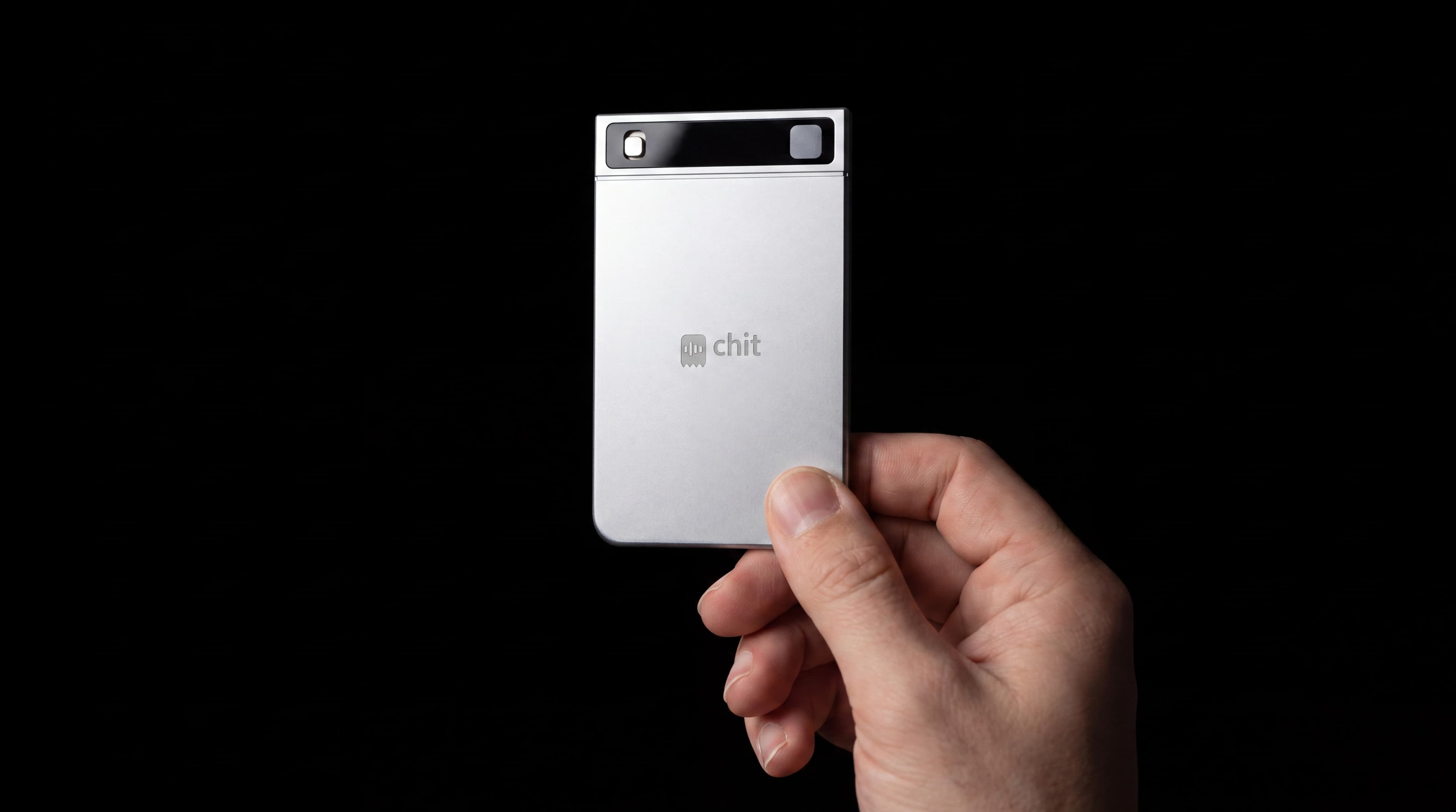 A hand holding chit one between thumb and forefinger, the card the size of a credit card.